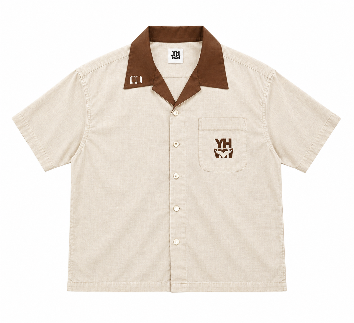 A short-sleeve button-up shirt in a light beige textured fabric, featuring a contrasting brown collar, a brown embroidered chest logo, and a matching brown embroidered book icon on the left collar.